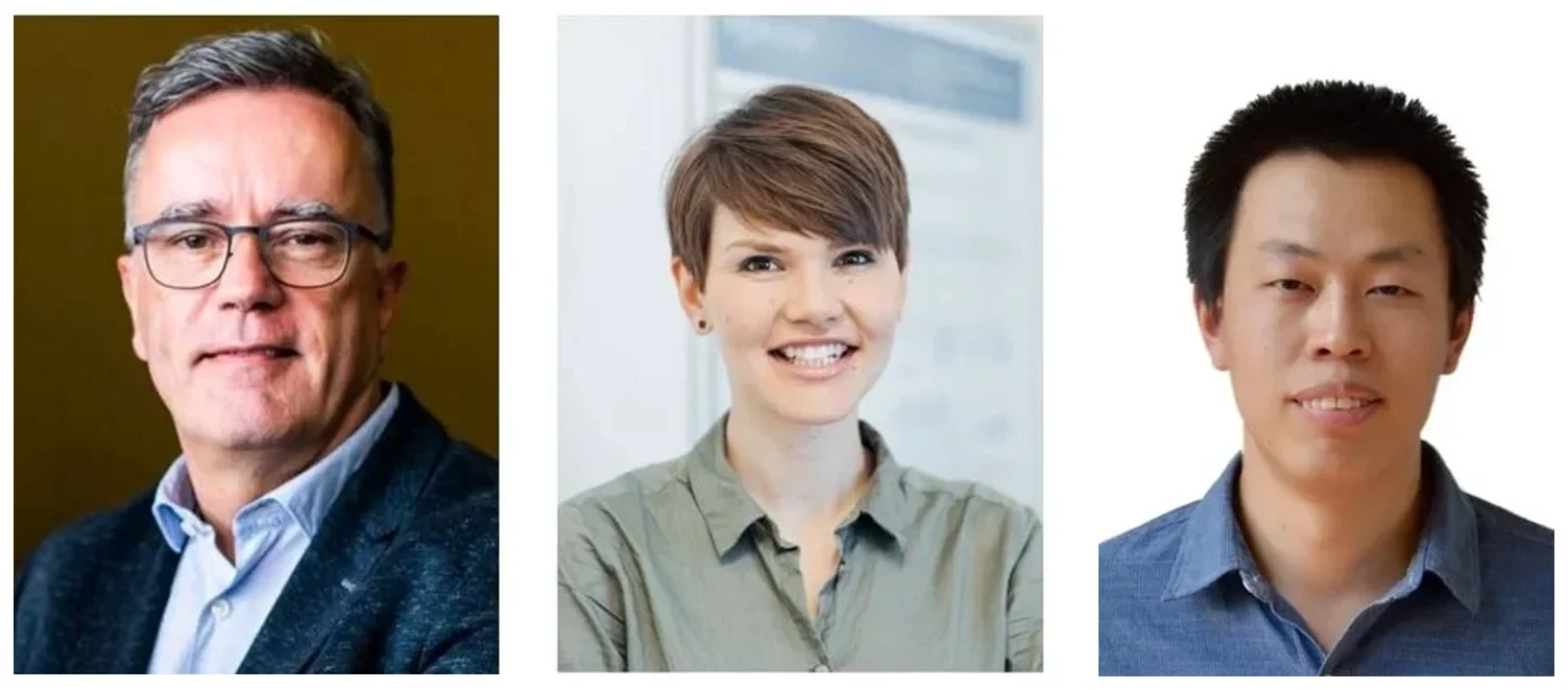 Eine Wissenschaftlerin und ein Wissenschaftler arbeiten hinter einer Glasfassade und mischen Chemikalien mit Großgeräten.